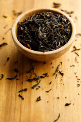 Japanese or Chinese jasmine tea leaf in wooden bowl on wooden background.