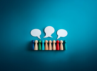 A diverse group of wooden figures is gathered below empty speech bubbles, suggesting communication, discussion, and sharing ideas on a blue background.