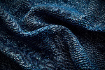 Folded dark blue denim fabric texture background for apparel design
