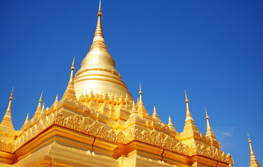 Naklejka premium Golden pagoda under the sunlight. This view is full of serenity and religious significance.
