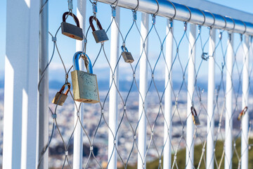見晴らしの良い展望台のフェンスにつけられた複数の南京錠