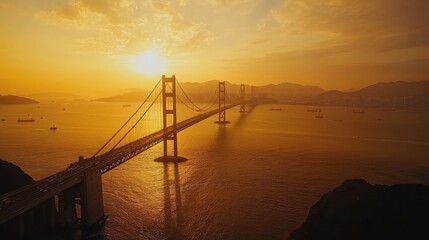 Obraz premium A panoramic aerial view of a long bridge spanning across the ocean at sunset, with golden skies and calm waters enhancing the beauty of the moment