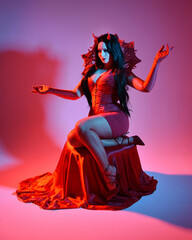 portrait of beautiful  female pin-up model wearing red dress with gothic fantasy burlesque...