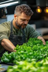 Man in Apron Tends to Fresh Greenery Under Warm Lights in Modern Kitchen Setting