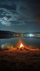 Obraz premium Campfire by the lake under the evening sky in the mountains
