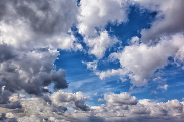 Clouds fill the sky, showcasing a dynamic mix of sunlight and shadows