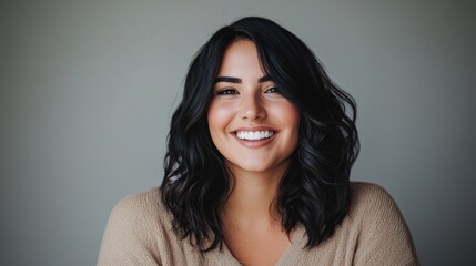 A beautiful woman with a warm smile and dark hair looking directly at the camera. Her cheerful demeanor makes for an inviting and approachable image.