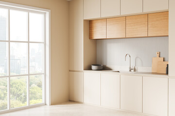 Fototapeta premium Bright modern kitchen interior with wooden cabinets and city view through large window. 3D Rendering