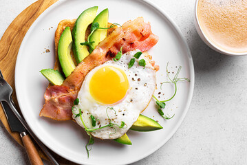 Toasted sandwich with fried egg, bacon, avocado