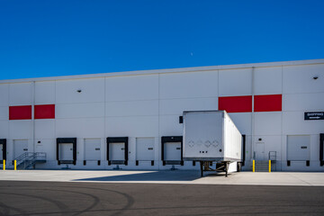 Dry van semi trailer without semi truck loading cargo standing in warehouse dock gate