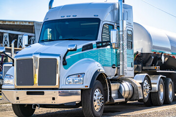 Professional big rig white and turquoise semi truck with extended cab and tank semi trailer...