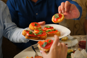 Multiethnic group of people at festive dinner table celebrating Thanksgiving together