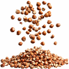 Obraz premium Hazelnuts falling onto a pile, isolated on white, food photography