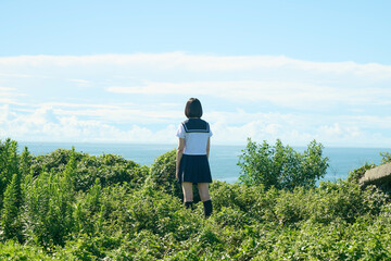海を見つめる女子高校生の後ろ姿