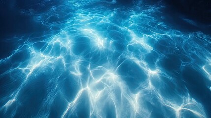 A breathtaking underwater shot of a tropical blue sea in Hawaii, with rippling light patterns on white sand.