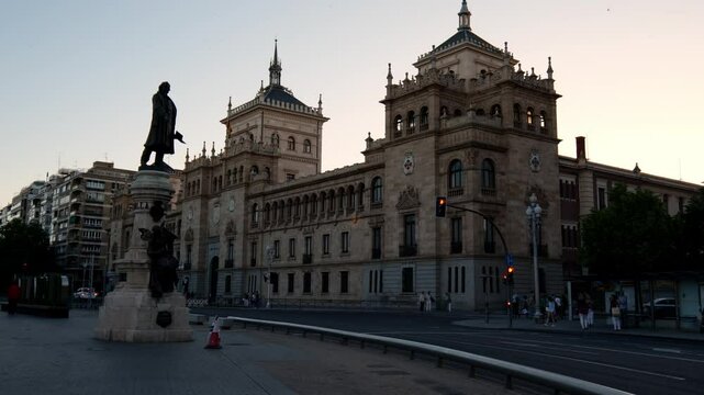 A view of the Jos&eacute; Zorrilla statue in Valladolid, Spain, with the historic Cavalry Academy in the background. A tribute to the famous poet, surrounded by architecture and cultural heritage.