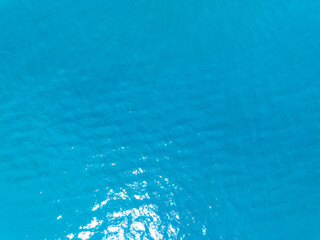 Aerial view of blue sea surface water texture background,Sun reflections on water, Aerial flying drone view Waves water surface texture on sunny tropical ocean in Phuket island Thailand