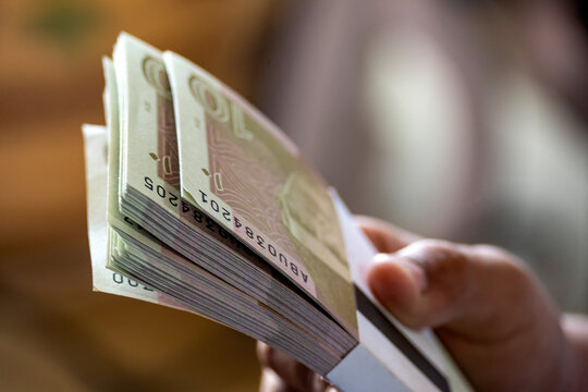 Karachi, Pakistan - April 23, 2024: Pakistani banknote bundles stacked on isolated background