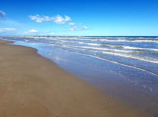 beautiful beach on the seashore under the blue sky with clouds