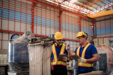 Professional engineer and young trainee technician holding tablet wearing safety uniforms workwear Inspection and maintenance planning the machinery in heavy industrial manufacturer factory.