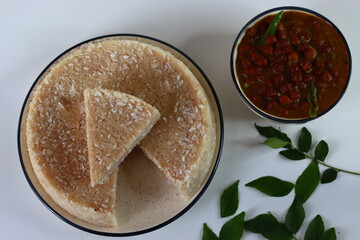 Paputtu or Paal Puttu made with matta rice, a Kerala brown rice, served with chickpea or Kadala masala curry.