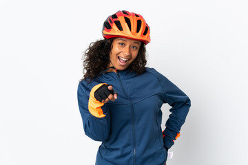 Teenager cyclist woman isolated on white background surprised and pointing front
