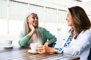Beautiful senior women bonding outdoors in the city - Attractive cheerful mature female friends having fun, shopping and bonding, concepts about elderly lifestyle