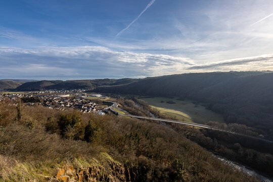 Steilhang mit Blick ins Tal, Fluss und Stra&szlig;e unter blauem Himmel