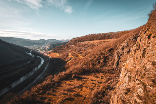 Steilhang mit Blick ins Tal, Fluss und Stra&szlig;e unter blauem Himmel