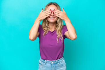 Young Russian woman isolated on blue background covering eyes by hands and smiling