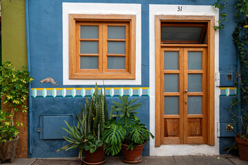 A blue building with a white trim and a number 33 on the door. The front of the building has a green and white tile pattern
