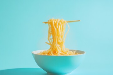 Noodles held by chopsticks over a bowl with blue background