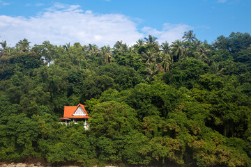Beautiful buildings on the mountain by the sea. Jungle on the hill. Sunny summer day.