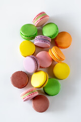 A vibrant assortment of colorful macarons arranged artfully on a white background, showcasing a delightful variety of flavors