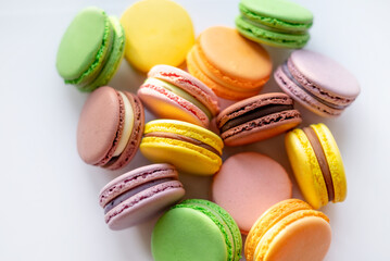 A colorful assortment of macarons in various pastel shades, beautifully arranged on a white surface, perfect for dessert lovers