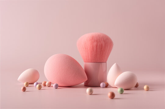 Aesthetic arrangement of pink makeup sponges, a blush brush, and pastel powder balls
