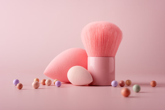 Aesthetic arrangement of pink makeup sponges, a blush brush, and pastel powder balls