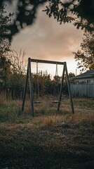 Fototapeta premium Swing Set in an Overgrown Backyard at Sunset with Dramatic Sky