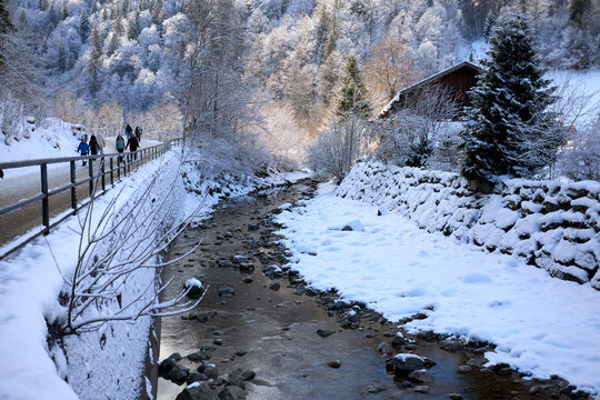 Tranquil Stream Through Snowy Village Scene