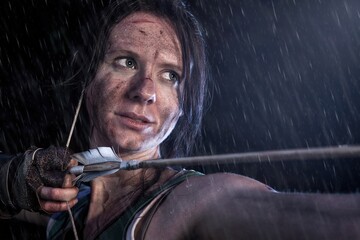 Moody Portrait of a woman adventurer with a bow and arrow in the rain