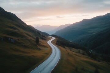 Winding mountain road through green valleys at dusk with a serene sky. Travel and adventure in nature