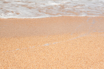 Wave hits the sandy beach