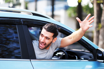 Latin man greeting someone while driving a car, Young Arabic man waving hand while sitting in acar.