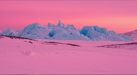 A series of jagged icebergs in a snowy landscape under a pink sky.