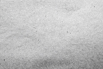 Close-up of a gray recycled paper texture with a rough surface and visible fibers, perfect for design projects.