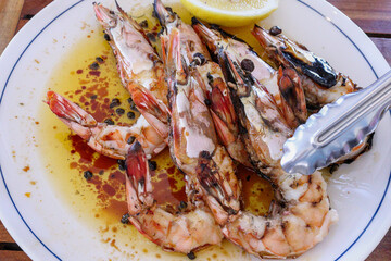 Appetizing grilled whole prawn, in lemon butter sauce. Slice of lemon. High in protein and omega-3, low in saturated fat. Produce of Australia