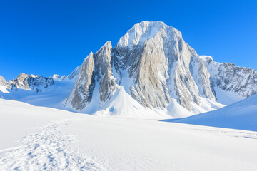 Naklejka premium Panoramic view of the stunning snowy Masherbrum peak in the Karakoram mountain range, with copy space. Crisp morning light. Clear blue sky background. 