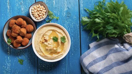 Delicious Hummus, Falafel, and Tahini on Rustic Wooden Table with Copyspace