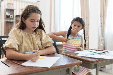 Group of children drawing and learning art in classroom at school