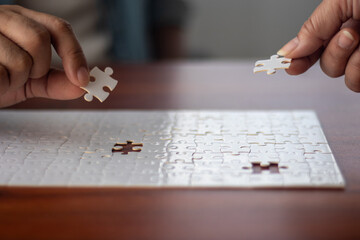Two people working together to put together a jigsaw puzzle.